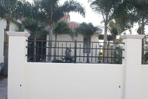 Photo of the courtyard wall built by our general contractor with palms and patio pavers beyond