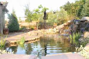 Waterfall behind a house in Lake County Florida with landscape and natural flagstone paving