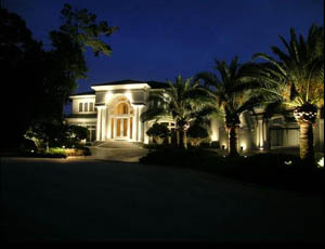 a house in Windermere Florida that is brightly lit with landscape lights and architectural landscape lights